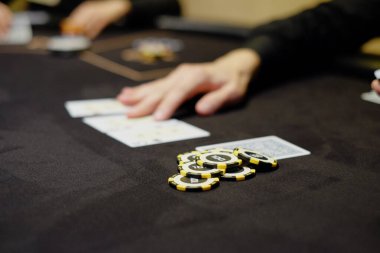 Krupiye ya da krupiye kumarhanedeki poker kartlarını masanın arka planında karıştırıyor. Poker konsepti, oyun işi. Para için oynamak, büyük bir galibiyet, büyük ikramiye, kumar, zengin olma arzusu..