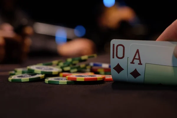 Dealer or croupier shuffles poker cards in a casino on the background of a table, chips. Concept of poker game, game business. Playing for money, a big win, a jackpot, gambling, a desire to get rich.