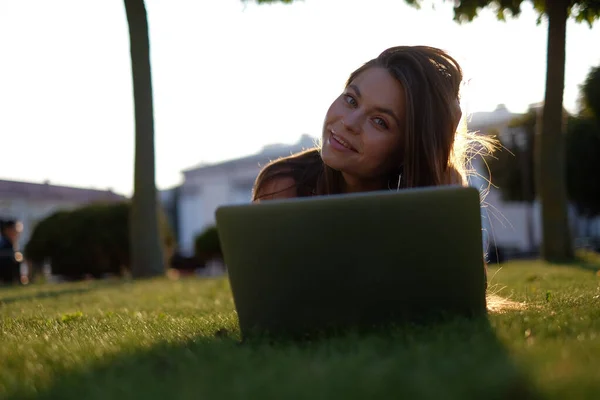 Молодая Женщина Использует Ноутбук Парке Лежащий Зеленой Траве Концепция Досуга — стоковое фото