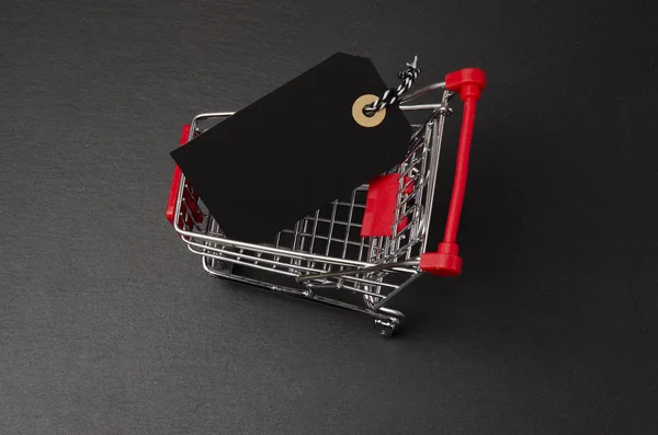 Shopping cart on the black background. Shopping card with a price tag. Shopping concept.