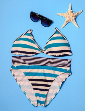 Yaz tatili düz kavramı mavi üzerinde yatıyordu. Bikini, güneş gözlüğü, deniz kabuklarını şapka. Tatil kavramı.