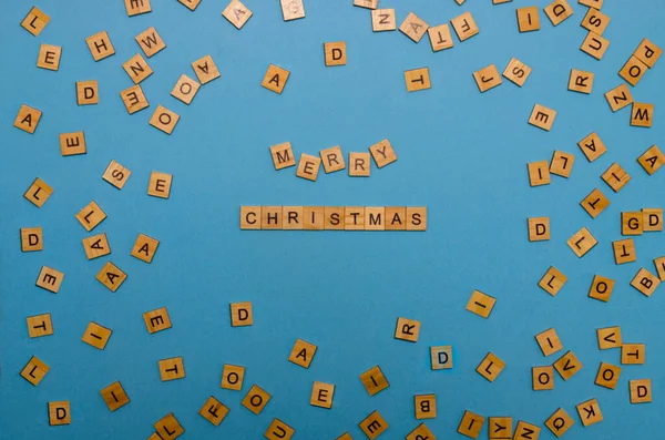 Feliz Navidad hecha de letras de madera sobre fondo azul. La inscripción Feliz Navidad hecha de bloques de madera. —  Fotos de Stock