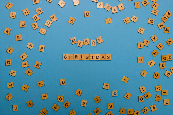 Веселого Рождества из деревянных букв на голубом фоне. Надпись "Счастливого Рождества из деревянных блоков".