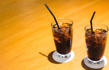 Buz ve saman cam masada Cola.