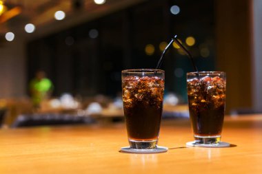 Buz ve saman cam masada Cola.