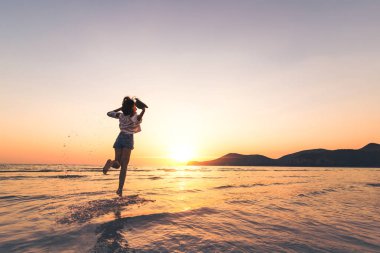 seyahat kadın şapka tutun ve dalga deniz atlamak.