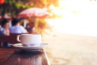 plaja yakın Ahşap üzerine kahve fincan sıcak.