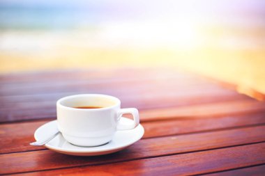 plaja yakın Ahşap üzerine kahve fincan sıcak.