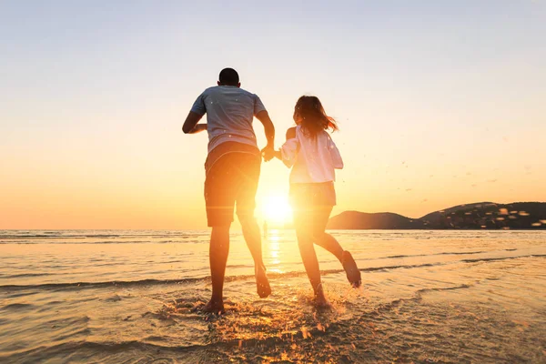 Par Löpning Och Hand Hålla Stranden Mellan Solnedgång — Stockfoto