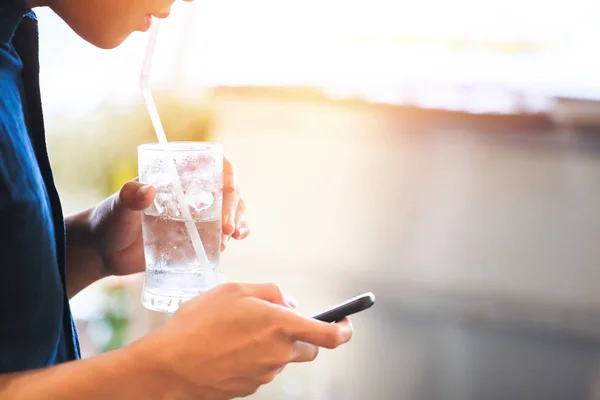 Человек Пьет Воду Соломы Пользуется Мобильным Телефоном — стоковое фото