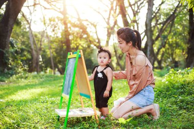 Anne ve kızı çizim kurulu ormandaki oynuyorlar.