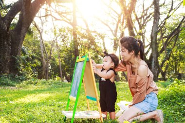 Anne ve kızı çizim kurulu ormandaki oynuyorlar.
