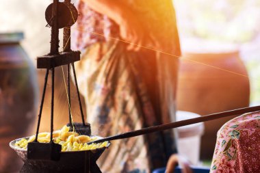 Sarı ipekböceği kozası ipek iplik yapmak için kazan tarafından kaynar.