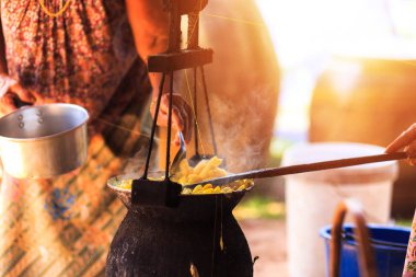 Sarı ipekböceği kozası ipek iplik yapmak için kazan tarafından kaynar.