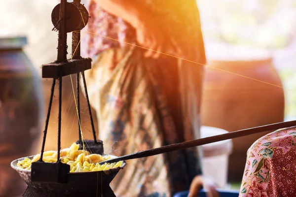 Sarı ipekböceği kozası ipek iplik yapmak için kazan tarafından kaynar.