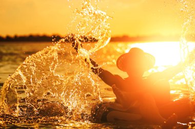 Bir adam ware şapka ve o suda yüzmek tüp oluyor. Su sıçrama yapmak için eller mi. 