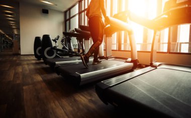 spor salonunda çalışan makine üzerinde çalışan insanlar.