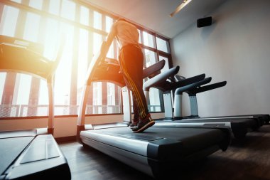 spor salonunda çalışan makine üzerinde çalışan insanlar.