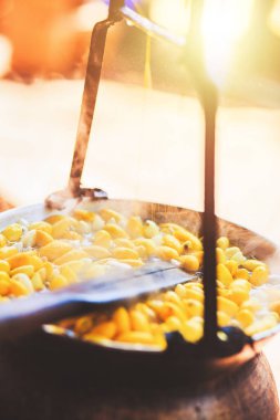 Sarı ipekböceği kozası ipek iplik yapmak için kazan tarafından kaynar.