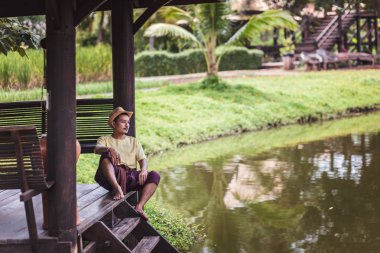 Adam giyim şapka için Nehri yakınında sakin ol arasında seyahat.