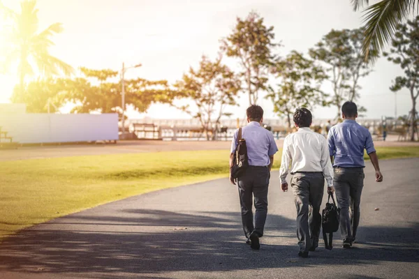 Back body.Businessman, They are walking on road in park. Photo concept business and relaxing time.