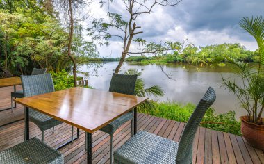 Nehir kenarında boş masa ve sandalyeler..