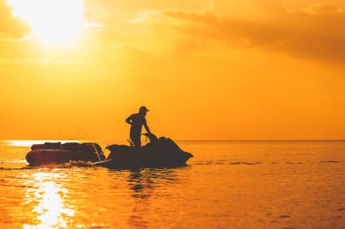 Muz tekne float gün batımı ile denizde jet ski ile.