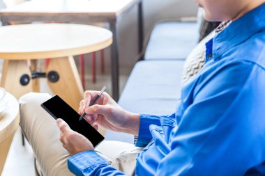 Bir iş adamı kısa not ve kahve dükkanında çalışmak için cep telefonu kullanmak.