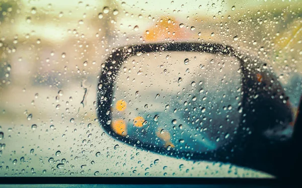 Blurred rain drop on the car glass background, water drops at the car window driver side.