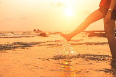 kadınlar arasında günbatımı sahilde su sıçrama oynamak