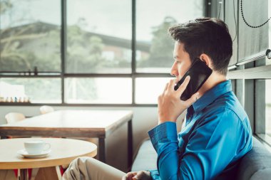 kafede otururken telefonla danışmanlık ortağı işadamı.