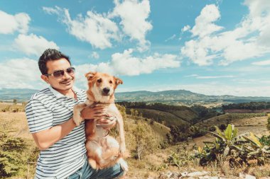  Köpeği olan bir adam. dağ ve mavi gökyüzü ve çok güzel bulutlar.