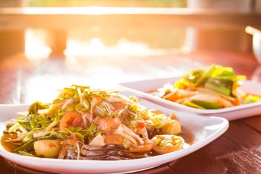 Baharatlı papaya salatası güneş ışığı ile ahşap masada Tay 