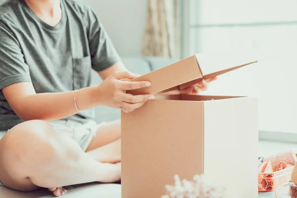 座っている人は 部屋でボックスを開く — ストック写真