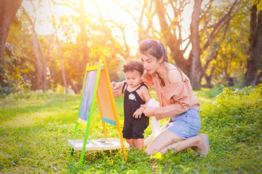Anne ve kızı çizim kurulu ormandaki oynuyorlar.