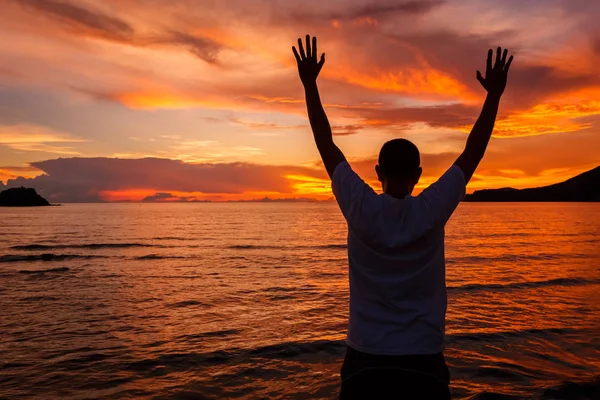 Счастливый Человек Поднятыми Руками Песчаном Пляже Наблюдающий Морем Горами Облаками — стоковое фото