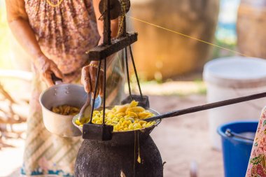 Sarı ipekböceği kozası ipek iplik yapmak için kazan tarafından kaynar.