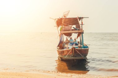 denizde ahşap balıkçı teknesi ve gün batımı, gün doğumu.