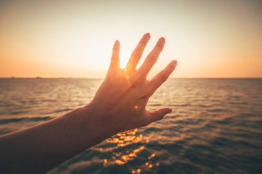 Gökyüzüne doğru uzayan bir adamın elini. Eli yapmak sembolü.