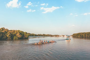 Turist bir grup ziyaret ve yüzen bambu sal üzerinde oturan. Yaz seyahati.
