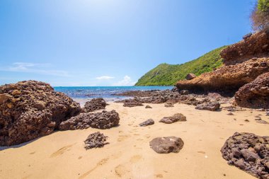 Plajkum ve mavi gökyüzü ile yeşil dağ üzerinde kaya öğle.
