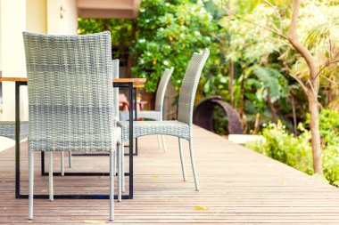 Otelde terasta boş masa ve sandalyeler.