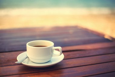 plaja yakın Ahşap üzerine kahve fincan sıcak.