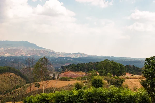 sıcak bir sonbahar gününde mavi bulutsuz gökyüzü altında beyaz sis ve yaprak döken orman kaplı dumanlı bir dağ dağ tepeleri bir görünüm
