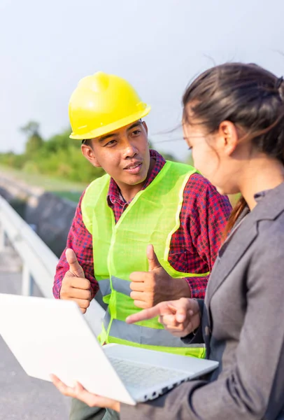 İş kadınları ve foreman birlikte konuşuyorlar. Şantiye inşaatında mühendis ve yönetici ekip çalışması ve kontrol .