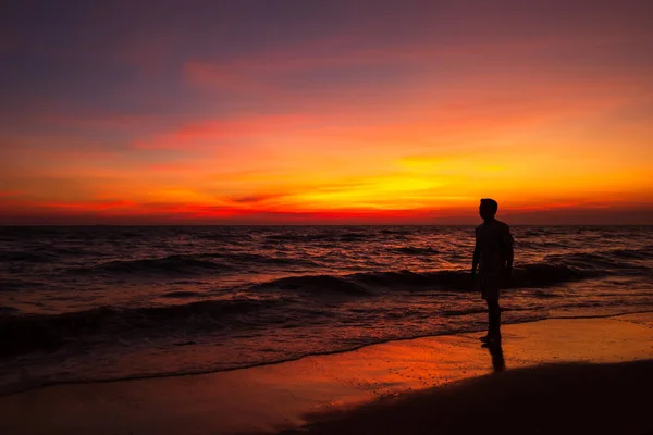 男がビーチと夕暮れの夕日の雲の上に立つシルエット — ストック写真