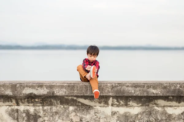 Ein Einsames Kind Zieht Die Schuhe Aus Und Sitzt Auf — Stockfoto