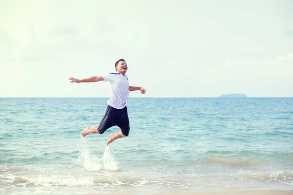 一个男人微笑着跳进海水和水的飞溅中 旅行夏天 放松概念 — 图库照片