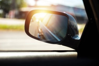 Bir araba yan ayna ve gün batımı yolda bir araba Yansıması.