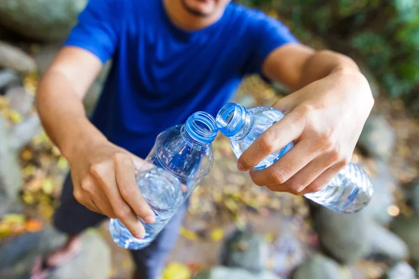 Eller su şişesi tutun ve su dökün.